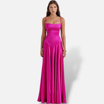 Modelo veste vestido maxi El Armario de Lola fúcsia acetinado com alças finas e corte justo elegante