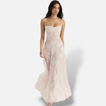 Modelo vestindo vestido maxi elegante El Armario de Lola em tom rosa claro com alças finas e padrão floral sutil