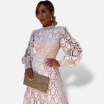 Vestido de renda El Armario de Lola bege com gola alta e mangas bufantes, usado por modelo com clutch