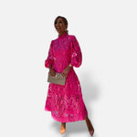 Vestido midi de renda fúcsia El Armario de Lola com gola alta e mangas bufantes, ideal para eventos formais de verão.